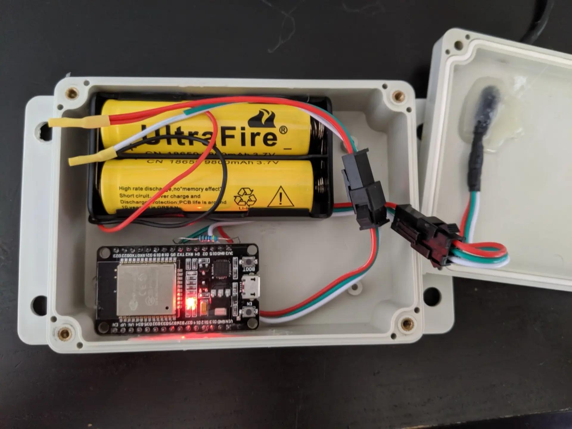 An esp32 in a project enclosure with two 18650 batteries in a simple battery case